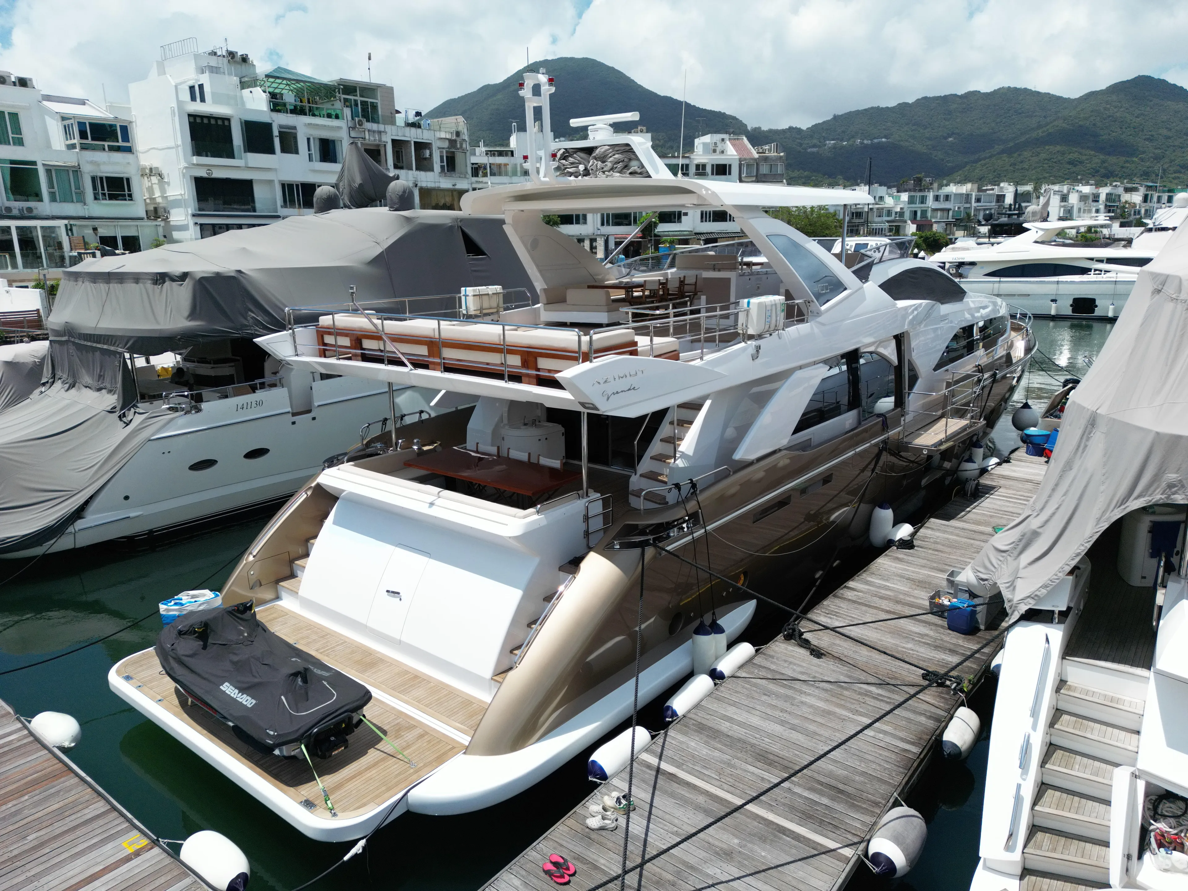  Yacht Photos Pics Luxurious 2016 Azimut 100 Grande yacht docked at a marina, surrounded by other boats.