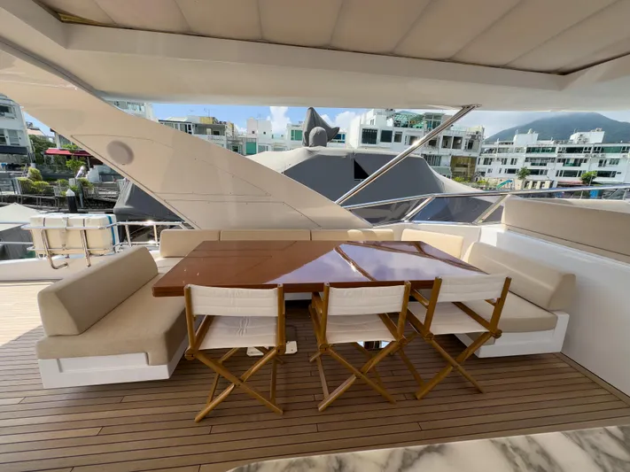  Yacht Photos Pics Outdoor seating area on 2016 Azimut 100 Grande yacht with wooden table and chairs.