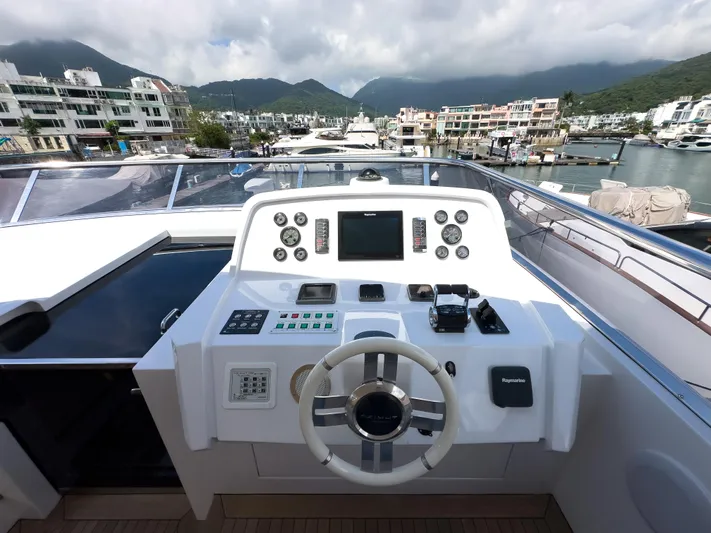  Yacht Photos Pics Helm of 2016 Azimut 100 Grande yacht with modern navigation controls, docked in a scenic marina.