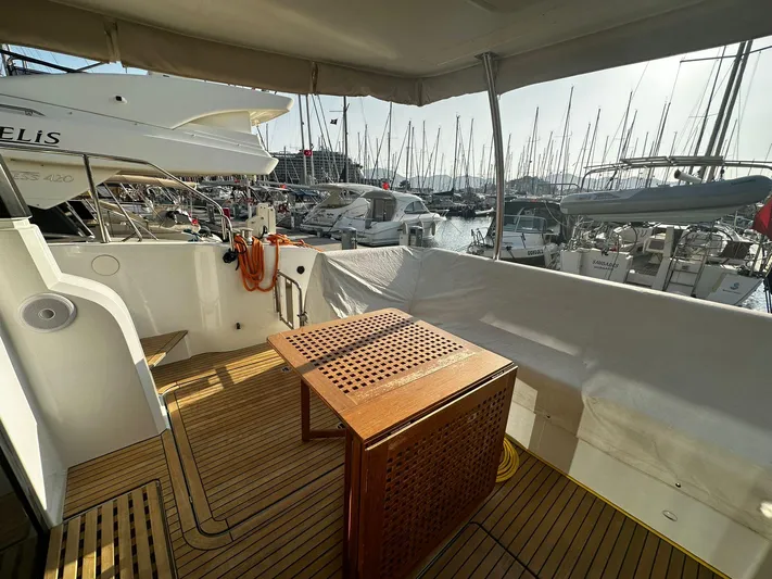  Yacht Photos Pics 2022 Fountaine Pajot MY5 yacht deck with wooden table, docked in marina.