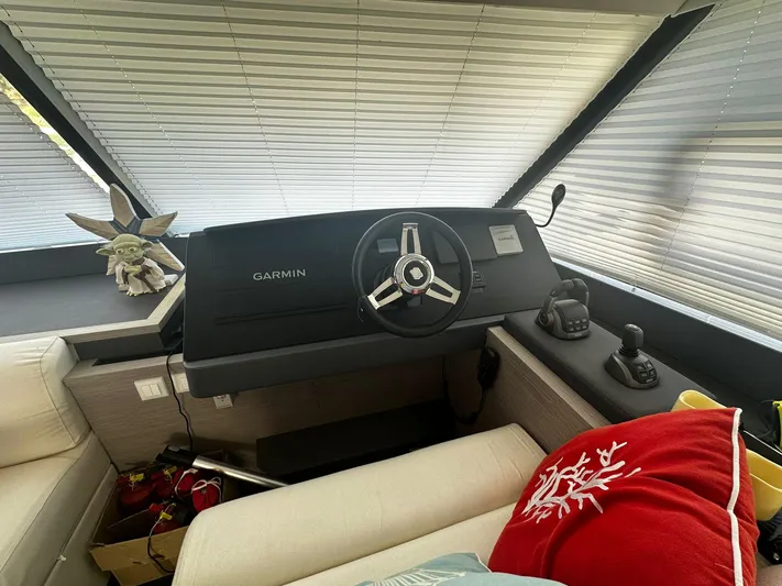  Yacht Photos Pics 2022 Fountaine Pajot MY5 helm with Garmin system, cozy seating, and decorative pillow.