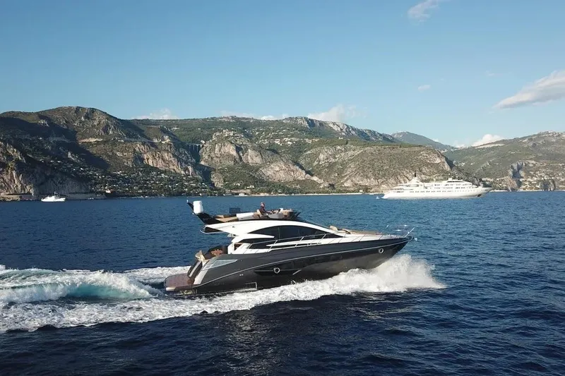  Yacht Photos Pics 2025 Cobrey 52 FLY yacht cruising near scenic coastal cliffs.