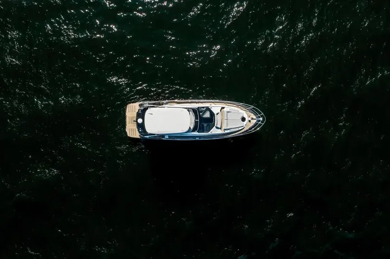  Yacht Photos Pics Aerial view of 2025 Cobrey 52 FLY yacht on dark water.