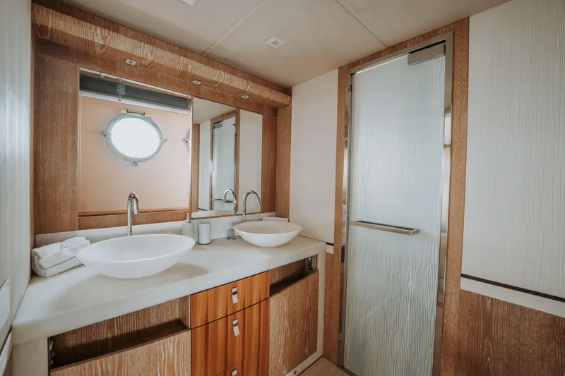 Venus Yacht Photos Pics Luxurious yacht bathroom with dual sinks, modern fixtures, and porthole window on Monte Carlo Yachts 86'7''.
