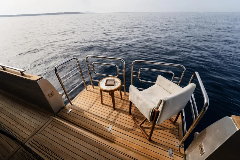 Venus Yacht Photos Pics Luxurious Monte Carlo Yachts 86'7'' deck with chair and table, overlooking serene ocean view.
