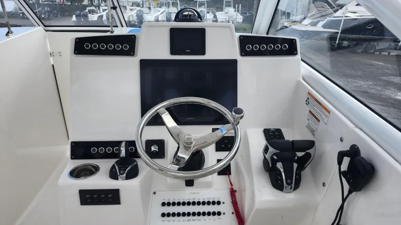 Yacht Photos Pics 2023 Edgewater 280 CX boat helm with modern controls and steering wheel.