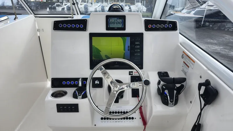  Yacht Photos Pics Edgewater 280 CX 2023 boat dashboard with steering wheel and navigation display.