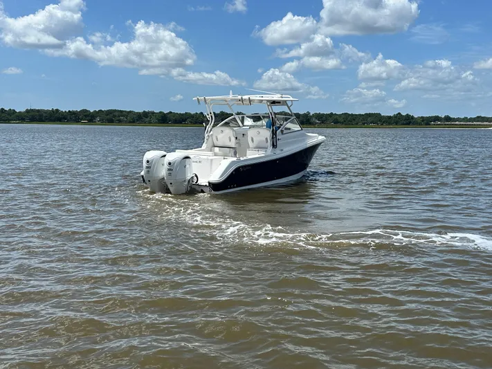  Yacht Photos Pics 2023 Edgewater 280 CX boat cruising on a sunny day with blue skies and clouds.