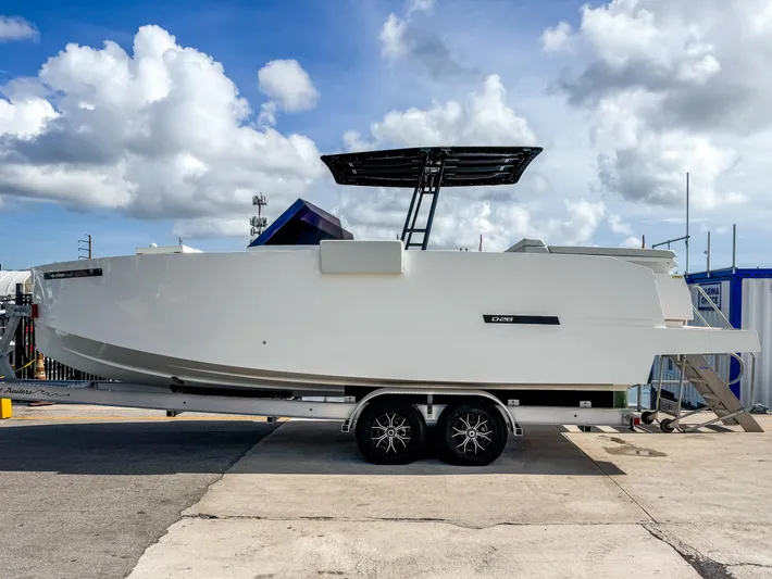  Yacht Photos Pics 2024 De Antonio Yachts D28 Open on trailer, side view under cloudy sky.