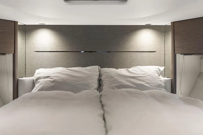 V50330 Yacht Photos Pics Luxurious bedroom interior of 2024 Princess V50 Open yacht, featuring elegant lighting and bedding.