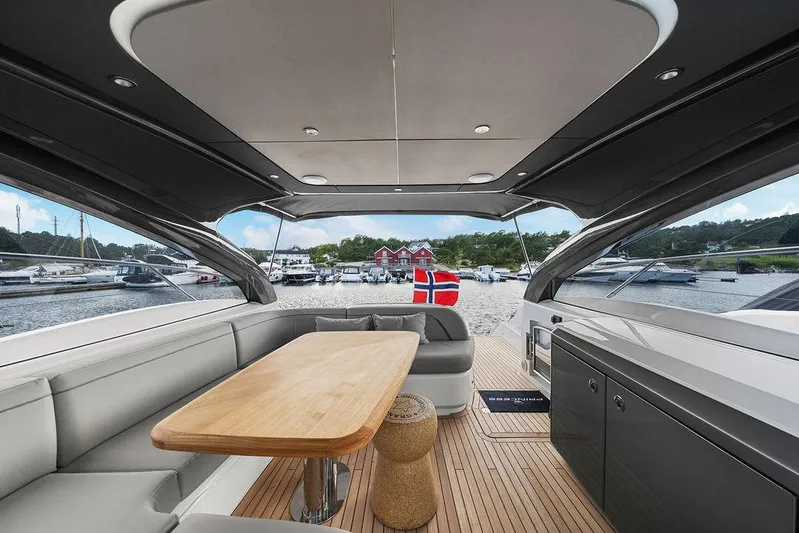 V50330 Yacht Photos Pics 2024 Princess V50 Open yacht interior with elegant seating and wooden table, docked at marina.