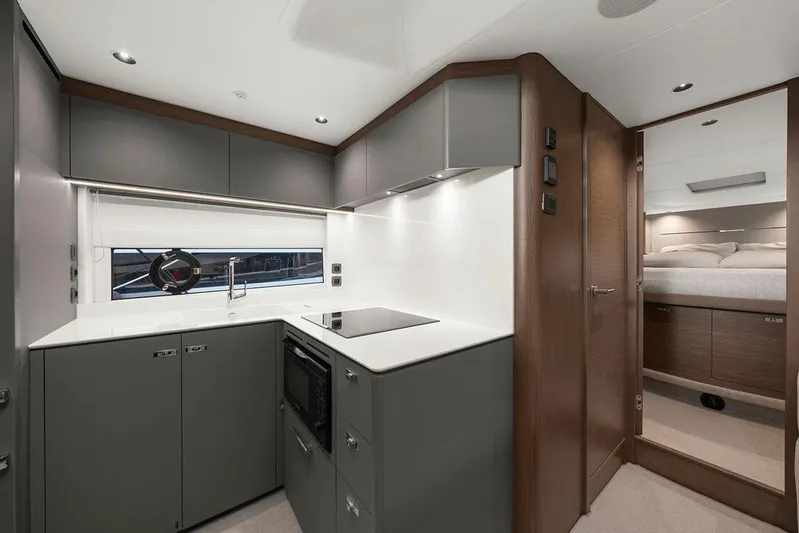 V50330 Yacht Photos Pics Modern kitchen interior of 2024 Princess V50 Open yacht, featuring sleek cabinetry and appliances.