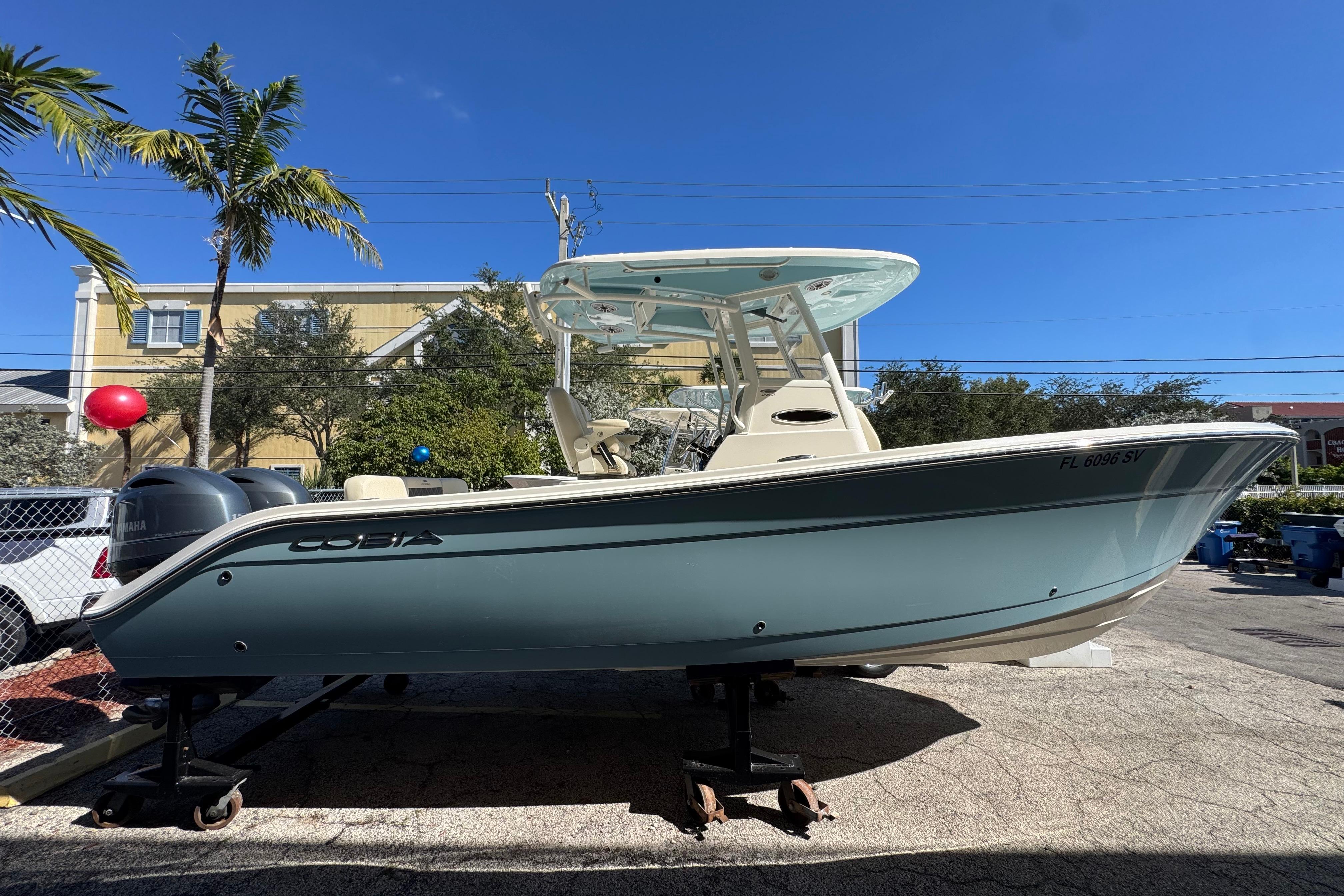 2021 Cobia 262 Center Console boat on display under clear blue sky.