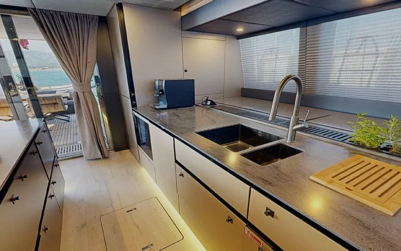 Catallaxi Yacht Photos Pics Luxurious kitchen interior of 2024 Sunreef 60 Sail yacht with modern fixtures and ample counter space.
