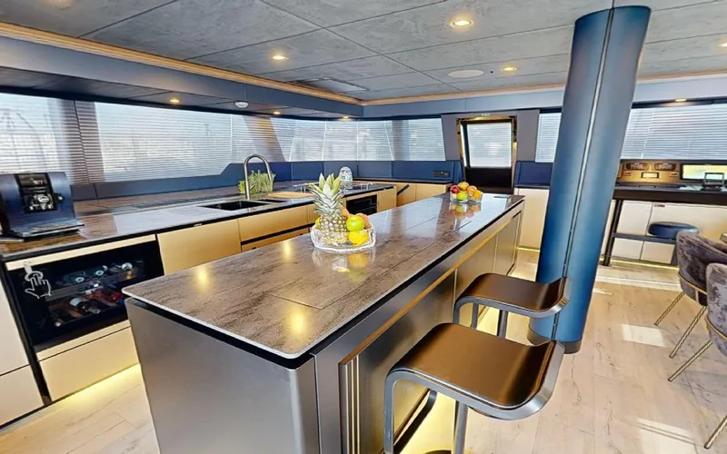 Catallaxi Yacht Photos Pics Luxurious interior of 2024 Sunreef 60 Sail yacht with modern kitchen and seating area.