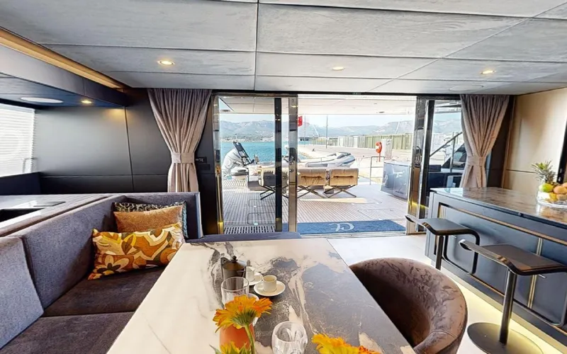 Catallaxi Yacht Photos Pics Luxurious interior of 2024 Sunreef 60 Sail yacht with elegant dining area and ocean view.