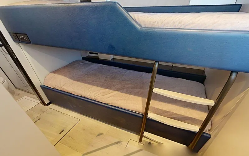 Catallaxi Yacht Photos Pics Bunk beds in 2024 Sunreef 60 Sail yacht cabin, featuring modern design and cozy bedding.