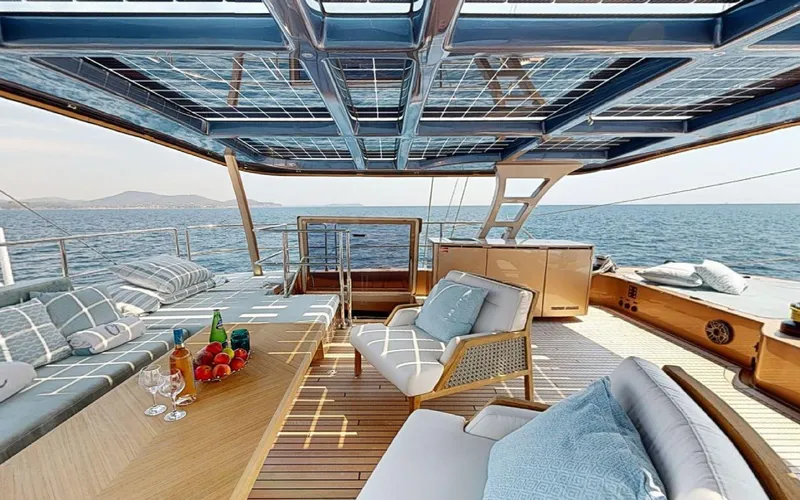 Catallaxi Yacht Photos Pics Luxurious Sunreef 60 Sail yacht deck with elegant seating, ocean view, and refreshments, 2024 model.