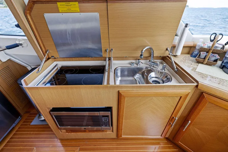 Cetacea Yacht Photos Pics Compact kitchen on 2008 Mochi Craft Dolphin yacht with stove, sink, and microwave.