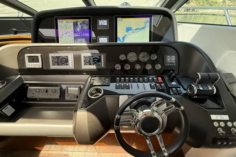 M/y Titan Yacht Photos Pics Control panel of a 2011 Sunseeker Predator 74 yacht with navigation screens and gauges.