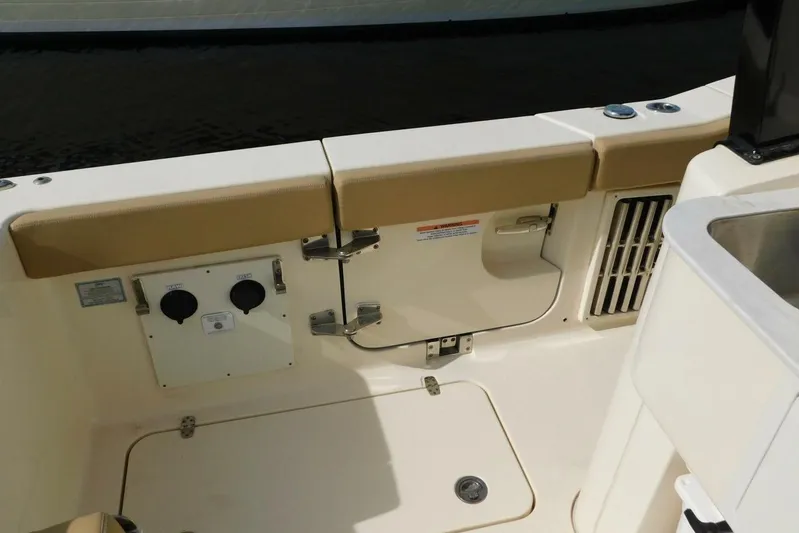  Yacht Photos Pics 2024 Scout 330 LXF boat interior with beige seating and utility access panel.