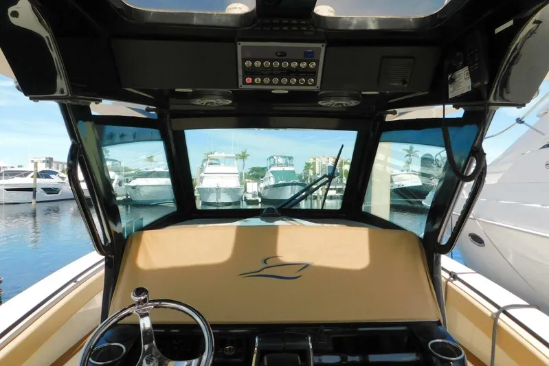  Yacht Photos Pics 2024 Scout 330 LXF boat interior with helm, marina view, and luxury features.