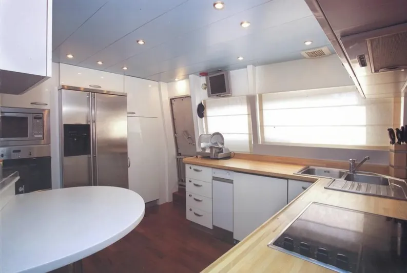  Yacht Photos Pics Modern kitchen interior on 2001 Castagnola 30 mt yacht, featuring stainless steel appliances and wooden countertops.