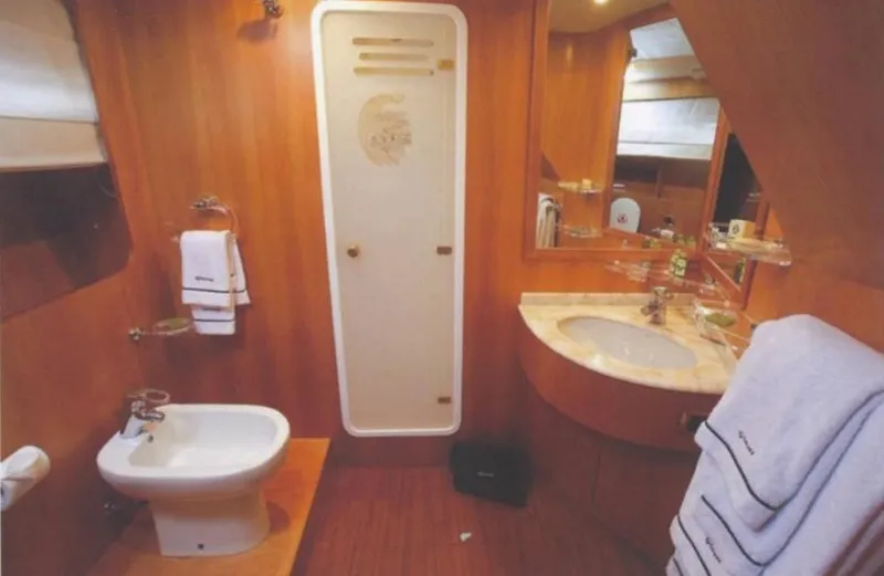  Yacht Photos Pics Luxurious yacht bathroom with wooden decor, marble sink, and elegant fixtures on a 2001 Castagnola 30 mt.