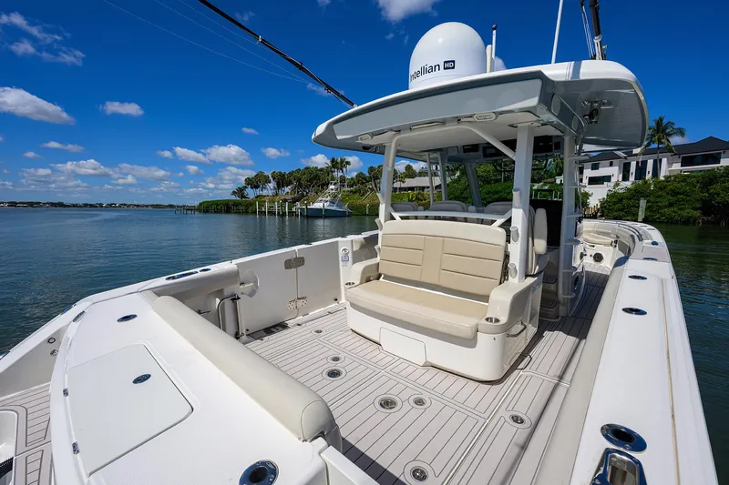 Who's Sippin Yacht Photos Pics Boston Whaler 380 Outrage 2021 boat with spacious deck and seating, docked by the water.