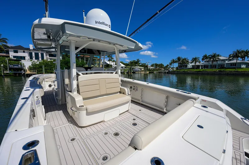 Who's Sippin Yacht Photos Pics 2021 Boston Whaler 380 Outrage boat with spacious deck and seating, docked by waterfront homes.