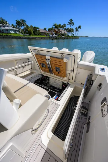 Who's Sippin Yacht Photos Pics 2021 Boston Whaler 380 Outrage boat interior with open storage, docked by tropical shoreline.