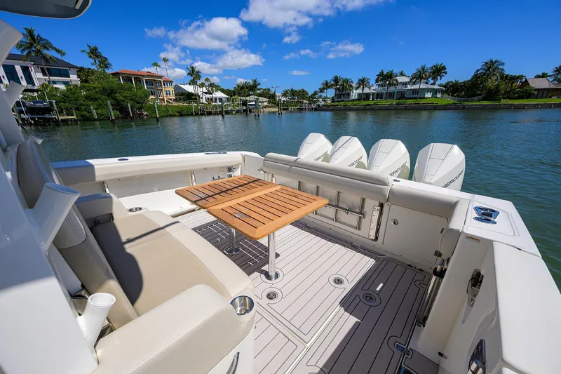 Who's Sippin Yacht Photos Pics 2021 Boston Whaler 380 Outrage boat with seating and table, docked by waterfront homes.