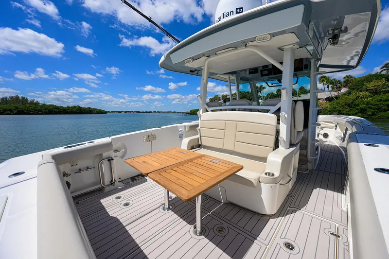 Who's Sippin Yacht Photos Pics 2021 Boston Whaler 380 Outrage boat interior with seating and table on a sunny day.