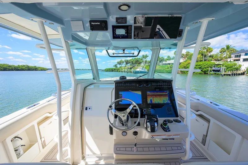 Who's Sippin Yacht Photos Pics 2021 Boston Whaler 380 Outrage helm with advanced navigation system on a scenic waterway.