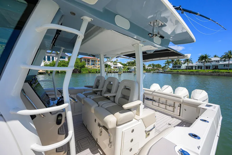 Who's Sippin Yacht Photos Pics 2021 Boston Whaler 380 Outrage boat interior with seating, docked by waterfront homes.