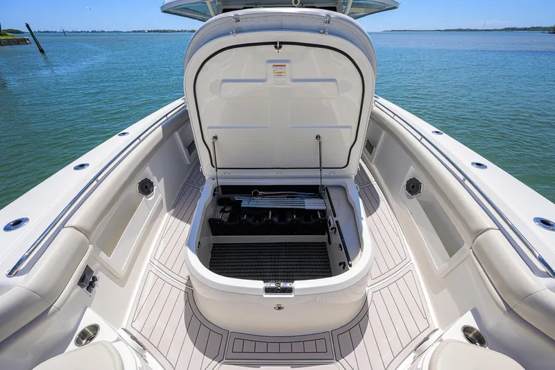 Who's Sippin Yacht Photos Pics 2021 Boston Whaler 380 Outrage boat with open storage compartment, docked on calm water.