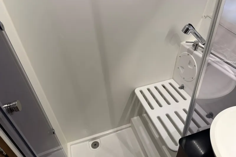  Yacht Photos Pics 2023 Jeanneau NC 1095 boat bathroom with shower and white fixtures.