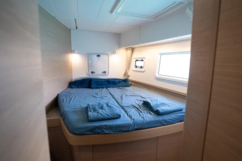 Tide Together Yacht Photos Pics Luxurious cabin interior of 2023 Lagoon 42 catamaran with cozy bedding.