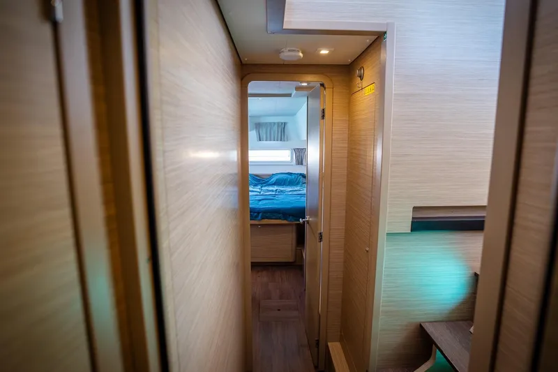 Tide Together Yacht Photos Pics Interior hallway of 2023 Lagoon 42 yacht, leading to a cozy bedroom.