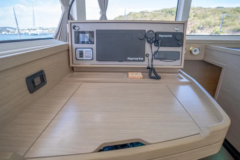 Tide Together Yacht Photos Pics Navigation station of 2023 Lagoon 42 catamaran with Raymarine equipment and wooden finish.