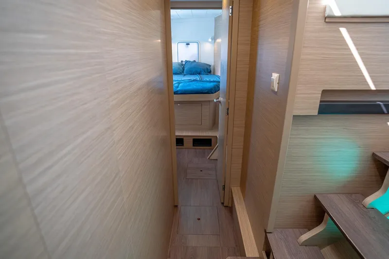 Tide Together Yacht Photos Pics Interior hallway of 2023 Lagoon 42 catamaran, leading to a cozy bedroom.
