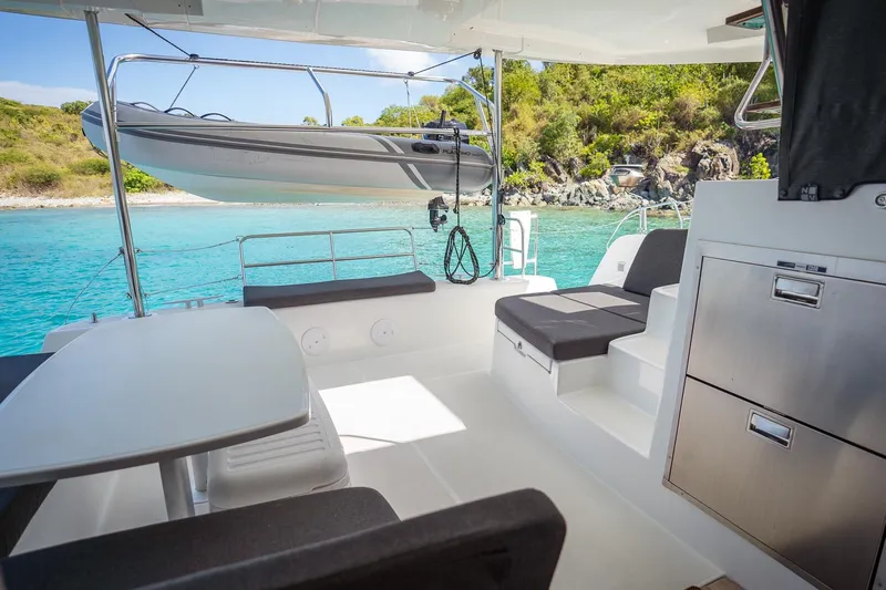 Tide Together Yacht Photos Pics 2023 Lagoon 42 yacht interior with seating, table, and scenic ocean view.