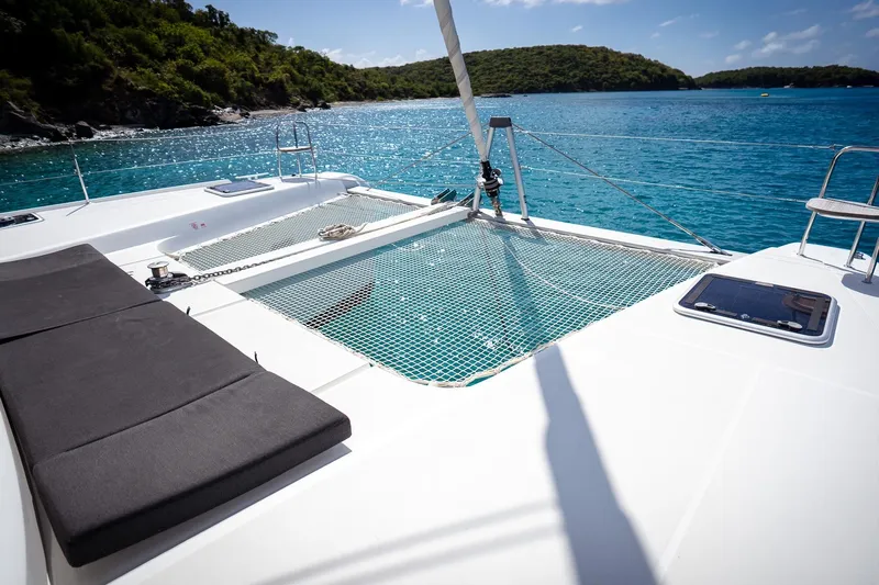 Tide Together Yacht Photos Pics 2023 Lagoon 42 catamaran on serene blue waters, featuring spacious deck and netting.