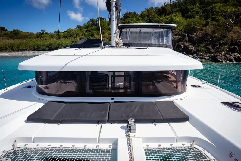Tide Together Yacht Photos Pics 2023 Lagoon 42 catamaran anchored in turquoise waters, featuring sleek design and spacious deck.