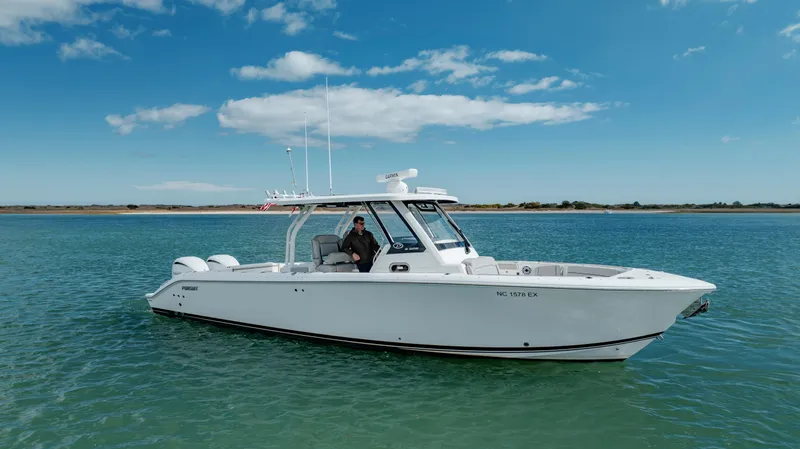 Mindy's Tyde III Yacht Photos Pics 2022 Pursuit S 328 boat on calm water with clear blue sky.