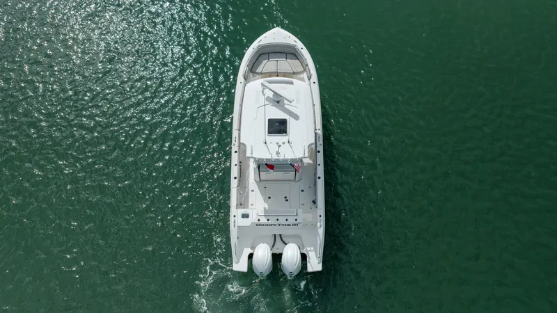 Mindy's Tyde III Yacht Photos Pics Aerial view of a 2022 Pursuit S 328 boat cruising on green water.
