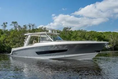 Aj Yacht Photos Pics 2020 Boston Whaler 420 Outrage boat on calm water with lush greenery background.