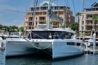 2022 Leopard 50 catamaran docked at marina with modern buildings in background.