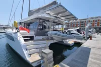 Modern Leopard 50 catamaran docked at marina, featuring sleek design and spacious deck, 2022 model.