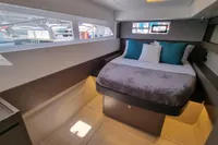 Luxurious cabin interior of a 2022 Leopard 50 yacht with modern bedding and ample natural light.